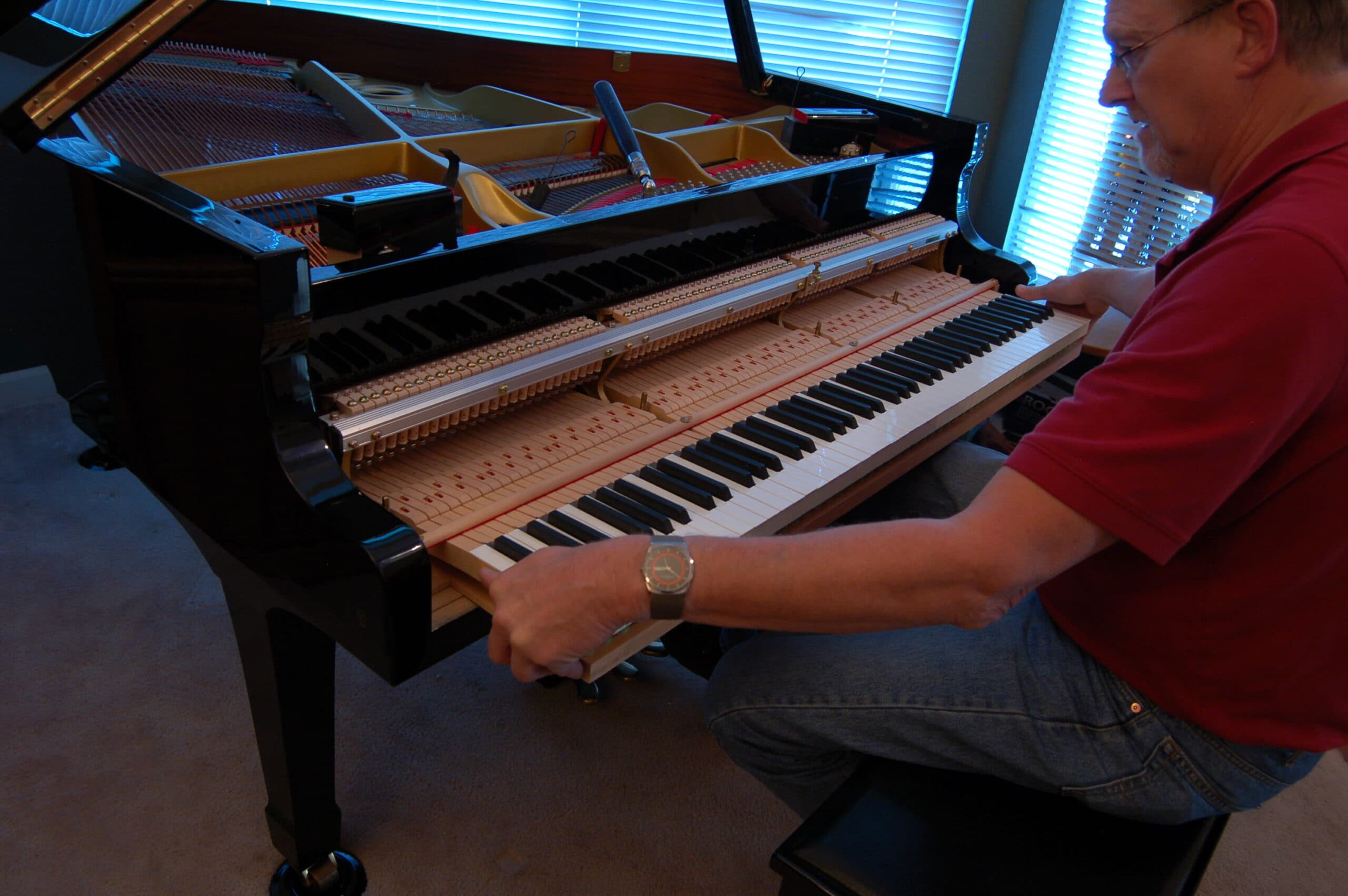 A technician working on the action of a grand piano